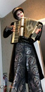 Stiltwalker holding an accordion