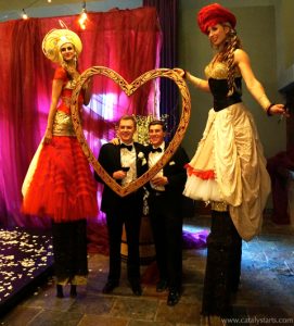 stilt walkers at wedding with big love heart frame photo experience- by www.catalystarts.com