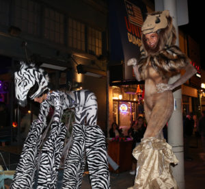 Two Stiltwalker Performers in Lion and Zebra Costume
