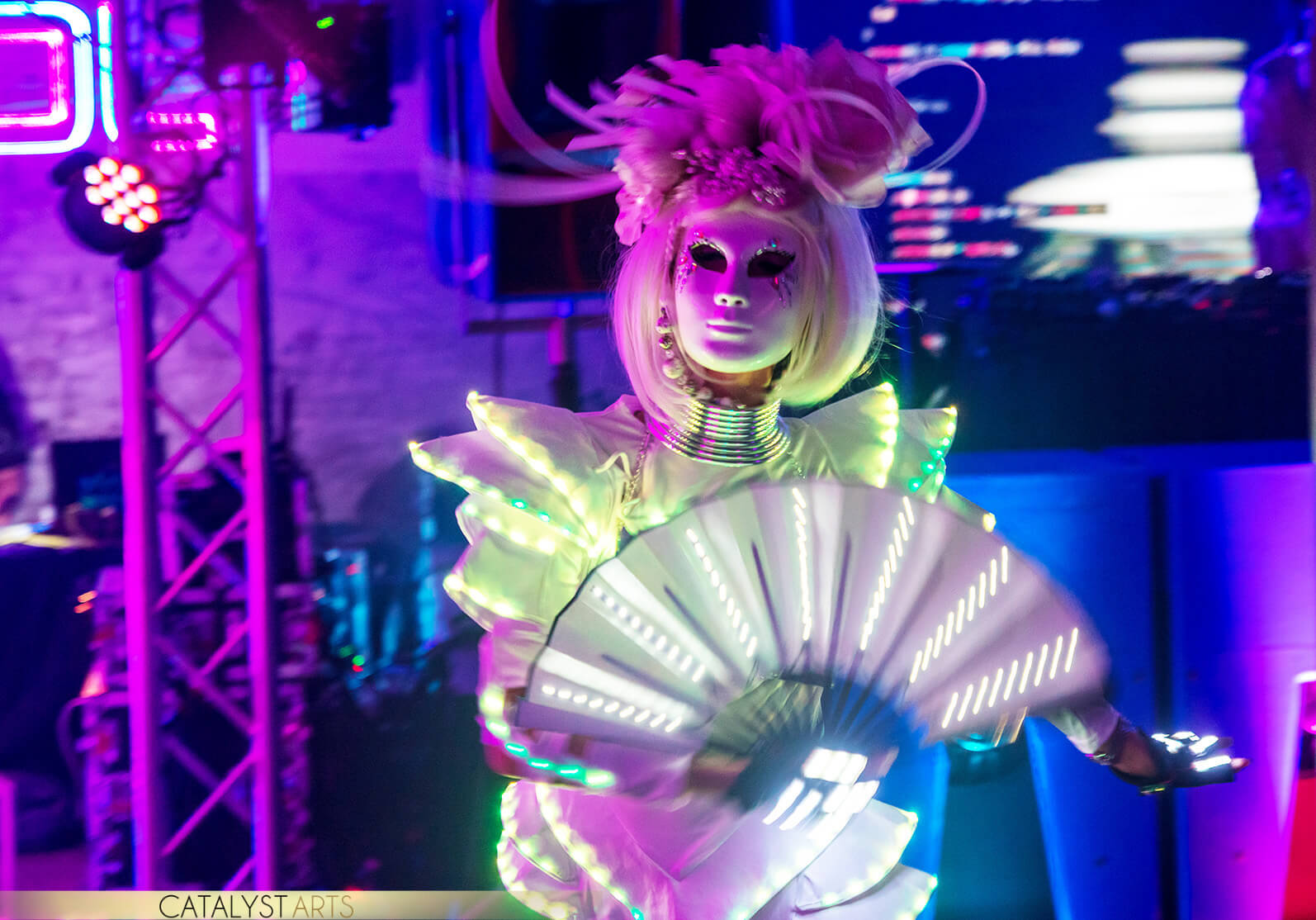 Futuristic Dancer wearing a white mark while holding a fan