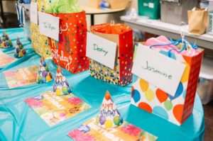 Colorful Gift Bags with Attendee name, Party hats and invitation cards