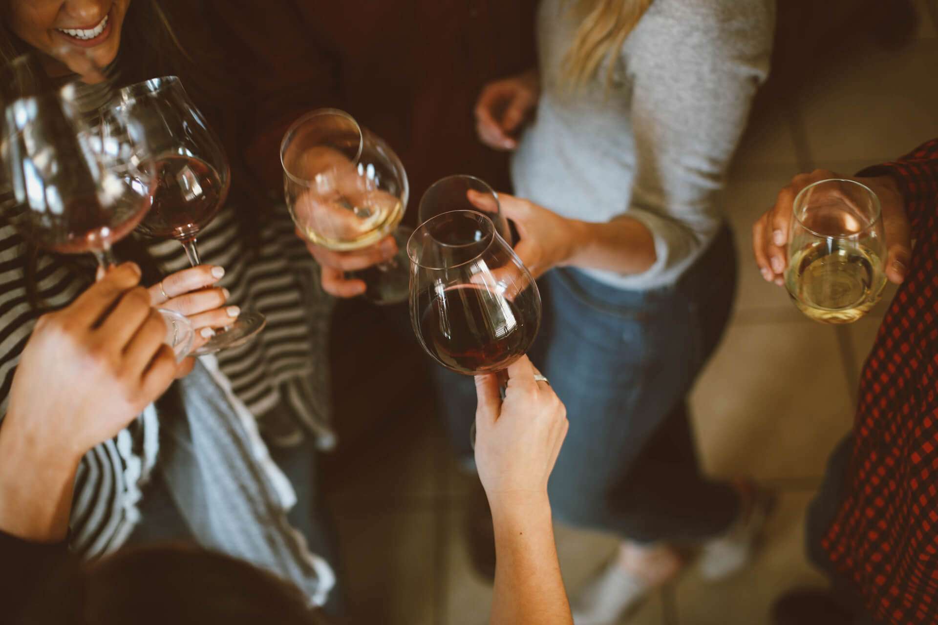 Group of people holding a wine glass with red and white wine