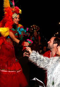 Samba Stiltwalker Giving Flower to Guests