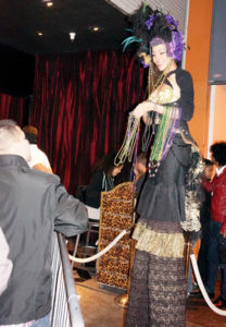 Mardi Gras Stiltwalker holding beads