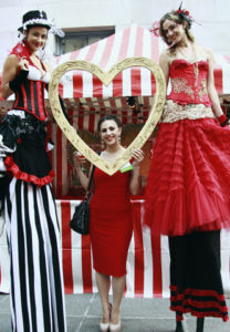 Circus Stiltwalker Duo Holding a heart frame for guest