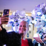 woman taking a selfie with two mirror dancers