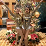 Two Mirror Showgirls standing infront of a Christmas Tree